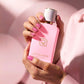 Rosamber Eau de Parfum pink bottle held in hands