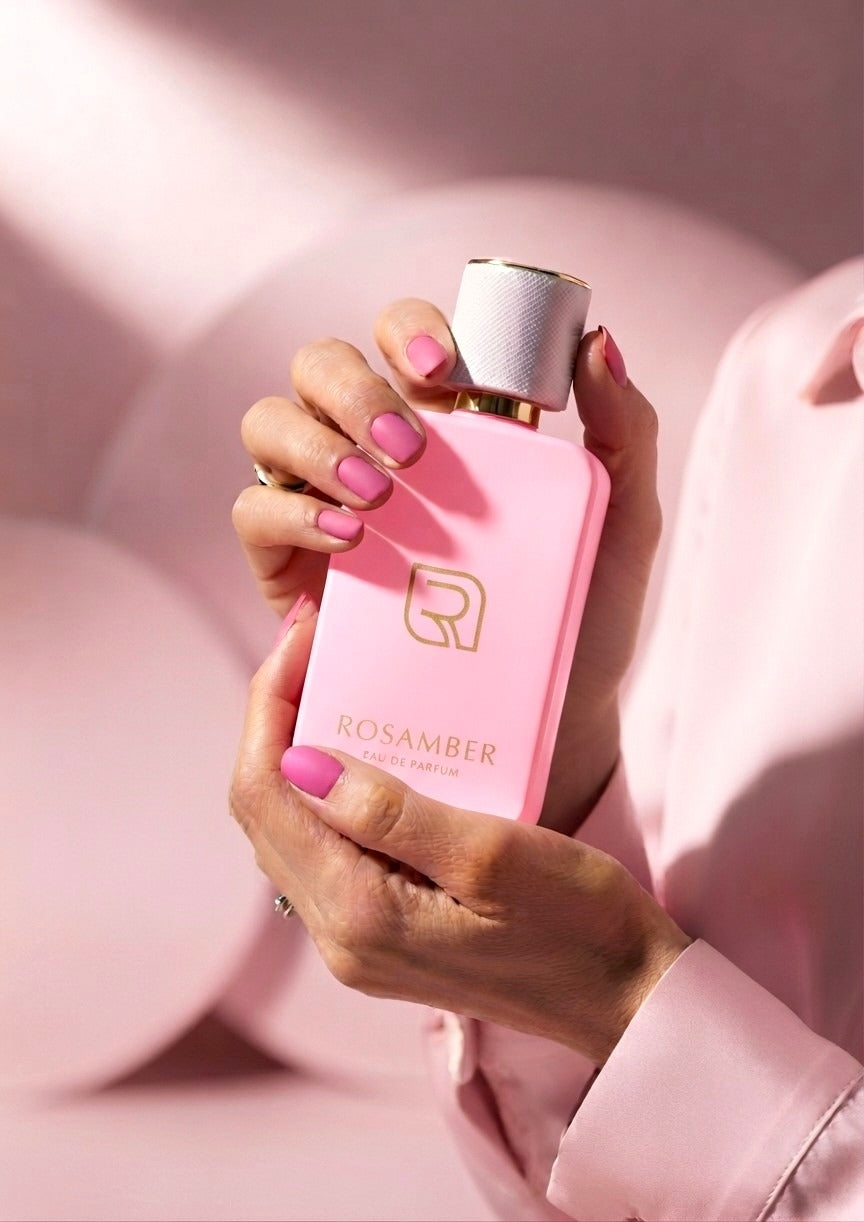 Rosamber Eau de Parfum pink bottle held in hands